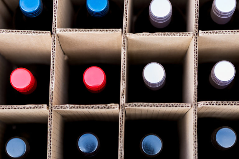 Top view of wine bottles in box, separated by grid partition