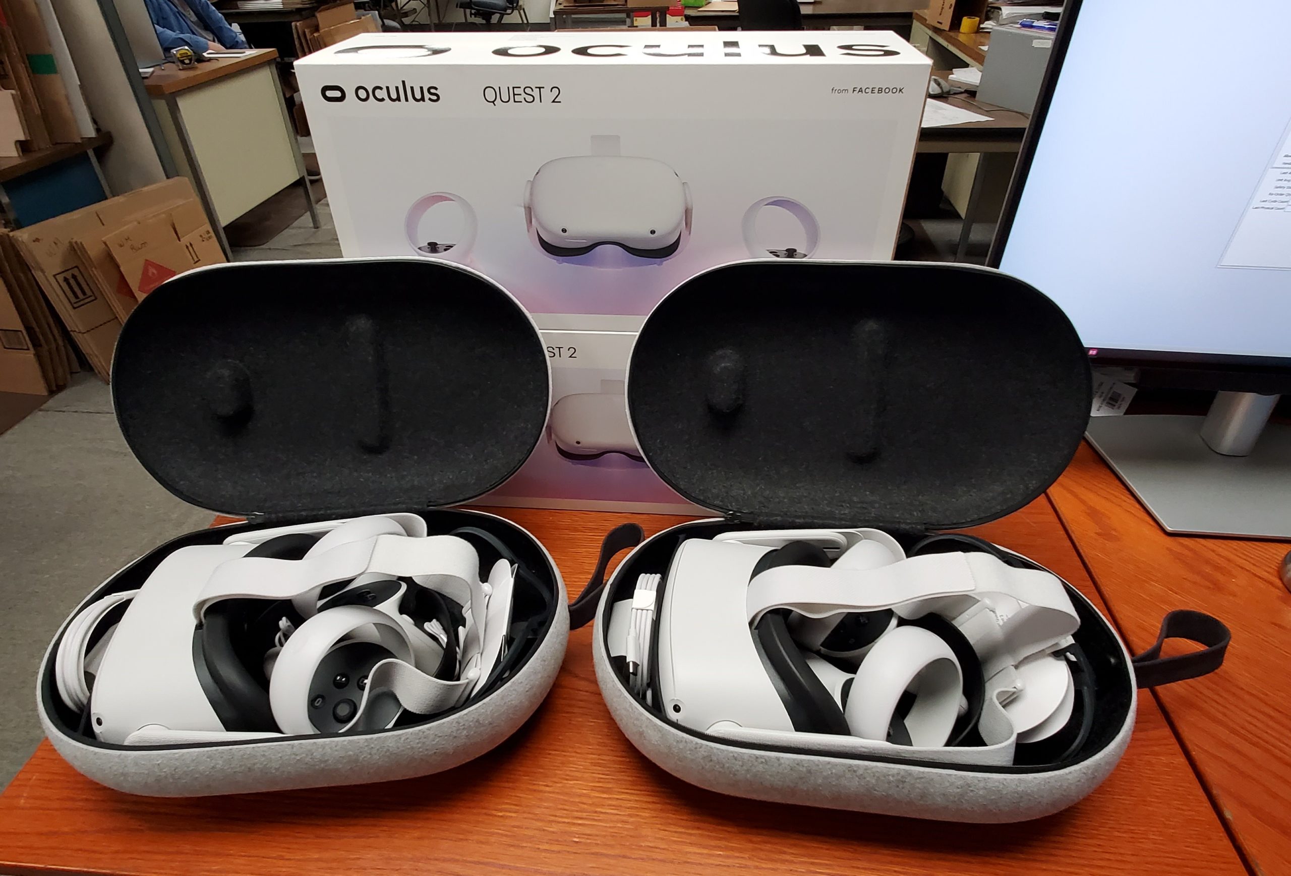 Oculus Quest 2 units sitting open, displayed in front of a product box in Wayne Automation offices for use in a virtual machine demonstration.