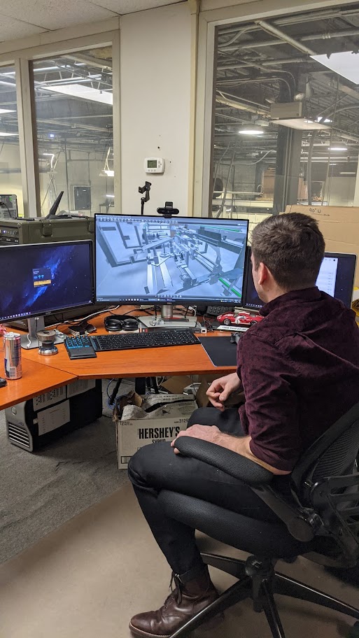 Engineer sits at workstation using CAD (computer-aided design) software to design end-of-line packaging equipment.