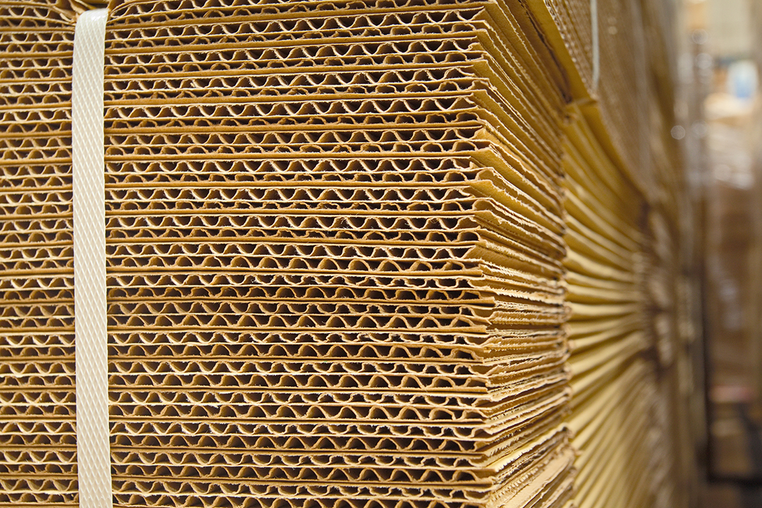  Flat stacked corrugated cardboard in a large warehouse