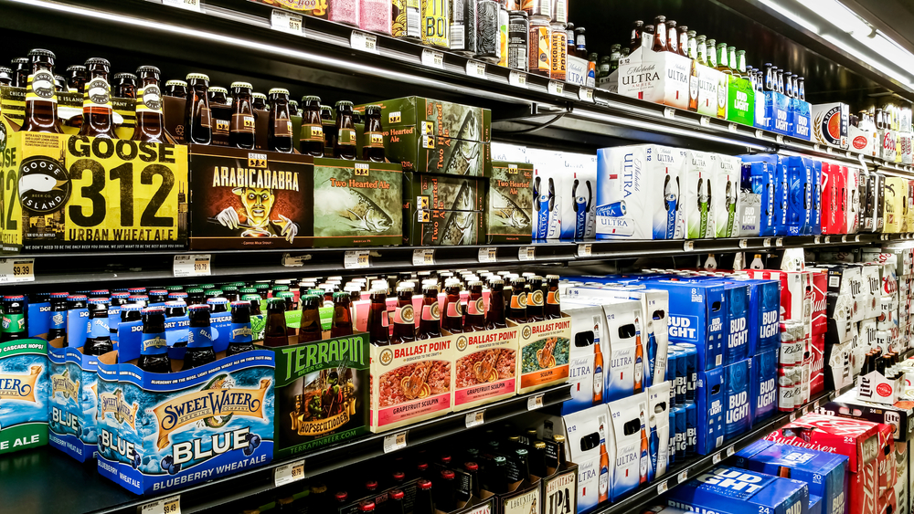 A variety of packaged beers on display for sale at a supermarket. 