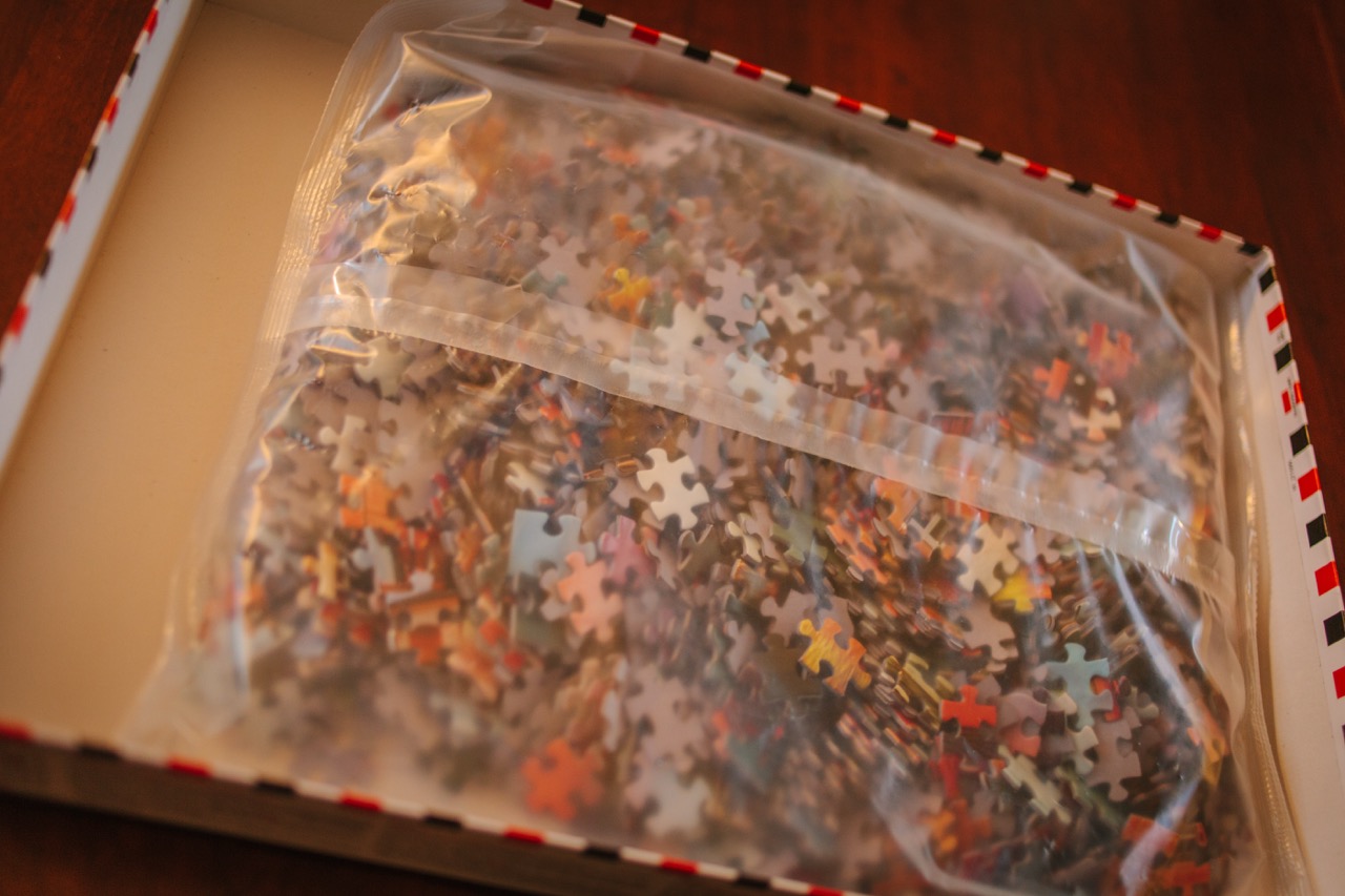 An unopened bag of jigsaw puzzle pieces packed by an automatic case packing machine.