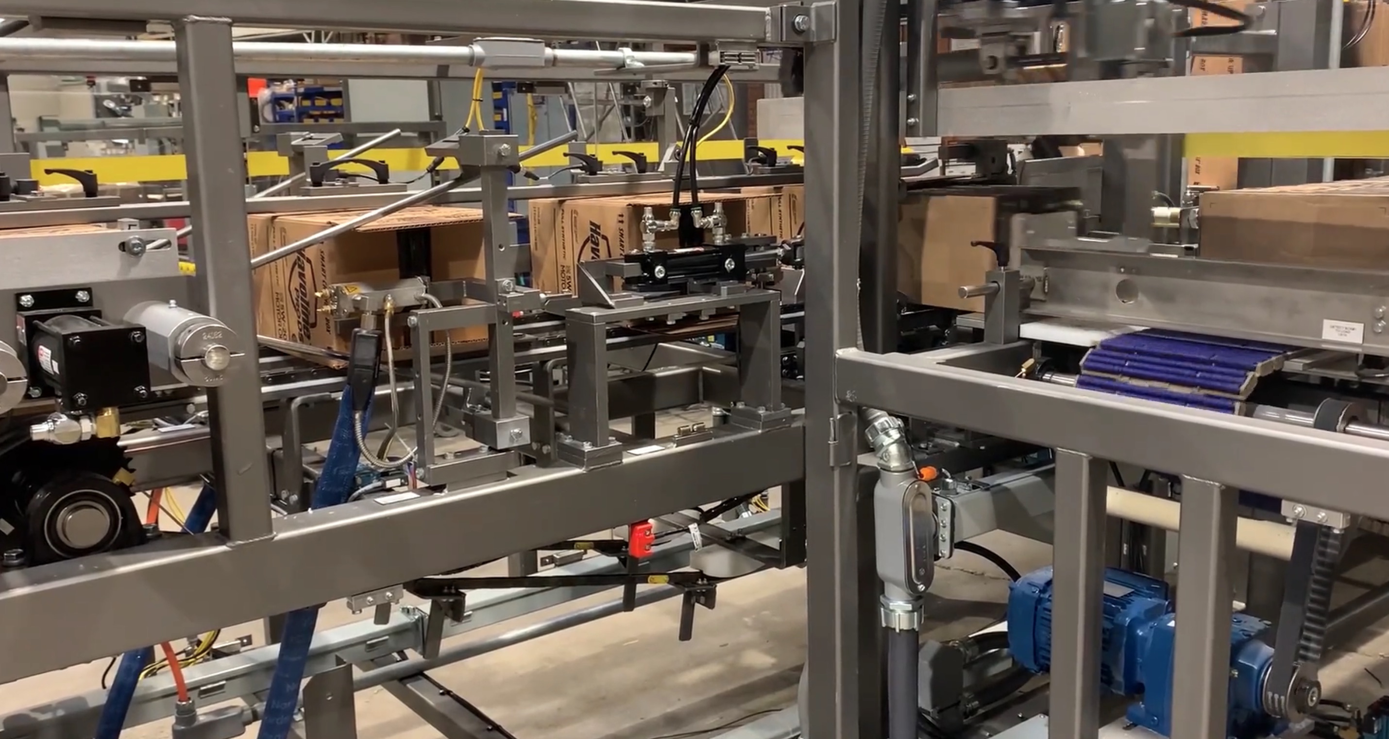 Automated case packer loading cardboard boxes on an end-of-line packaging system. 