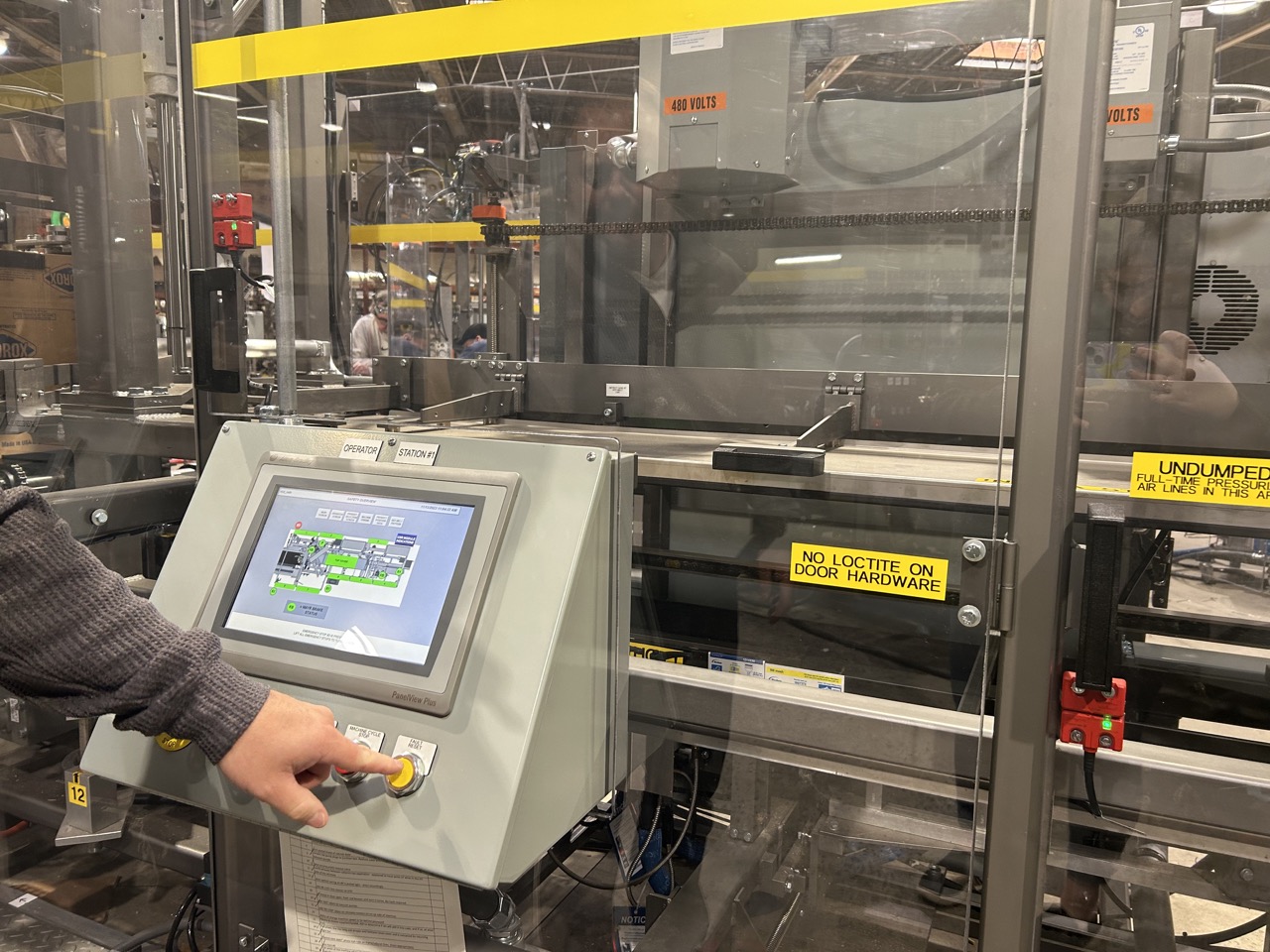 Operator using HMI controls on a packaging machine to perform a quick changeover between product configurations. 